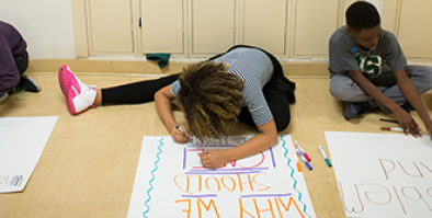 young student creating an informational poster.