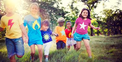 kids with superhero t-shirts playing in a park