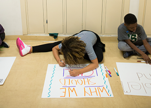 young student creating an informational poster.