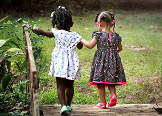 Two little girls walking hand-in-hand