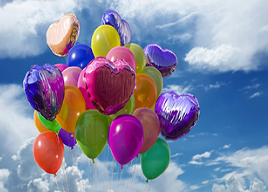 An assortment of balloons floating into the sky