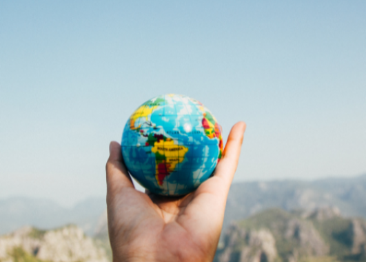 Hand holding a small globe.